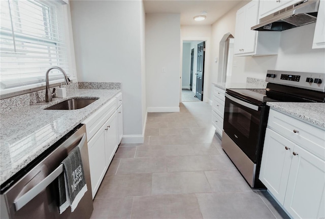 kitchen with light stone countertops, sink, wine cooler, white cabinets, and appliances with stainless steel finishes