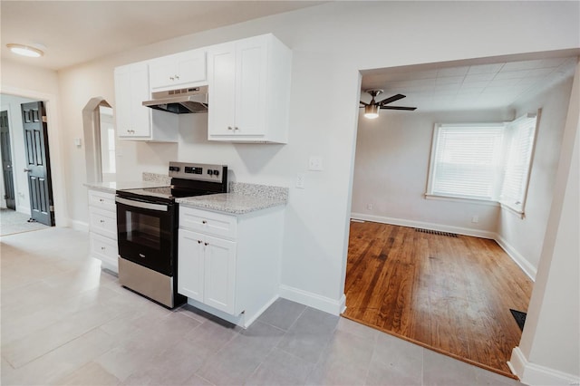 kitchen featuring white cabinetry, ceiling fan, light stone counters, and stainless steel range with electric stovetop