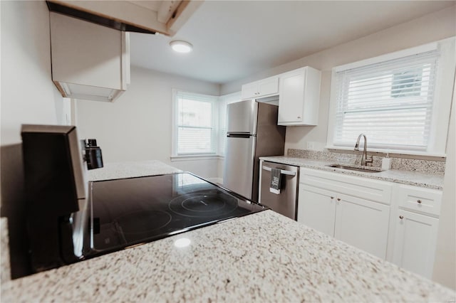 kitchen with white cabinets, light stone countertops, sink, and appliances with stainless steel finishes