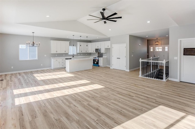 interior space with white cabinets, a kitchen island, hanging light fixtures, and appliances with stainless steel finishes