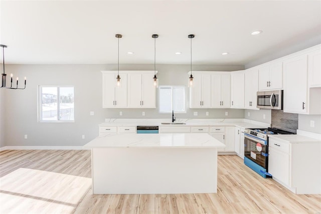 kitchen with white cabinetry, sink, a kitchen island, and appliances with stainless steel finishes