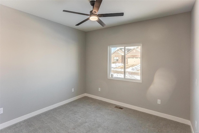 carpeted spare room featuring ceiling fan