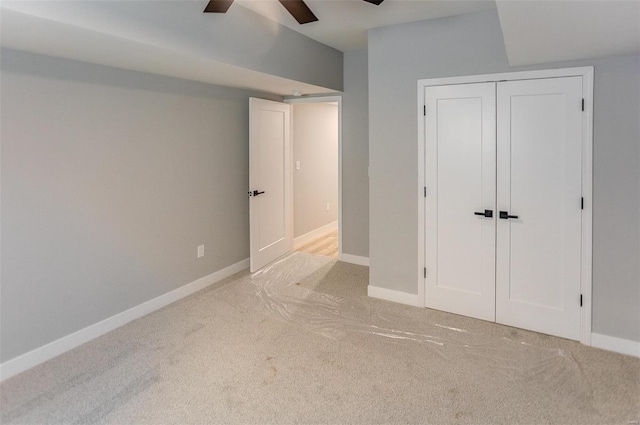 unfurnished bedroom with ceiling fan, a closet, and light carpet