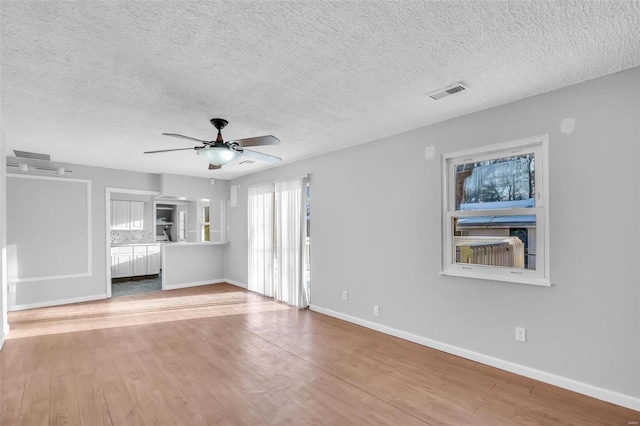 interior space featuring ceiling fan, a textured ceiling, and light hardwood / wood-style floors