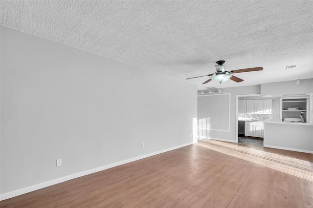 unfurnished living room with ceiling fan, a textured ceiling, and light hardwood / wood-style floors