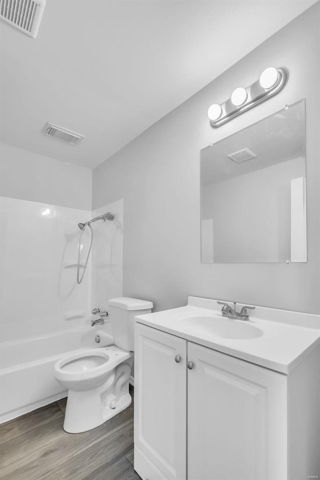 full bathroom with toilet, wood-type flooring, vanity, and bathtub / shower combination