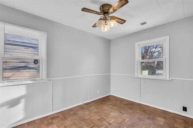 empty room featuring ceiling fan and parquet floors