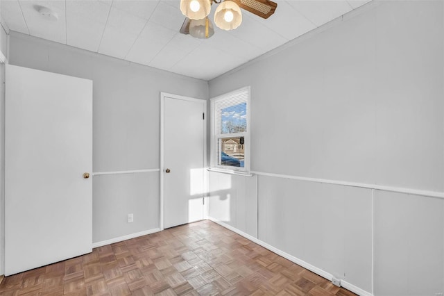 spare room featuring ceiling fan and parquet floors