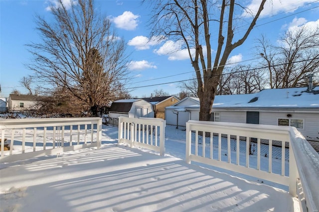 snow covered deck featuring a storage unit