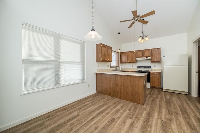 kitchen featuring sink, range with electric cooktop, white fridge, kitchen peninsula, and wood-type flooring