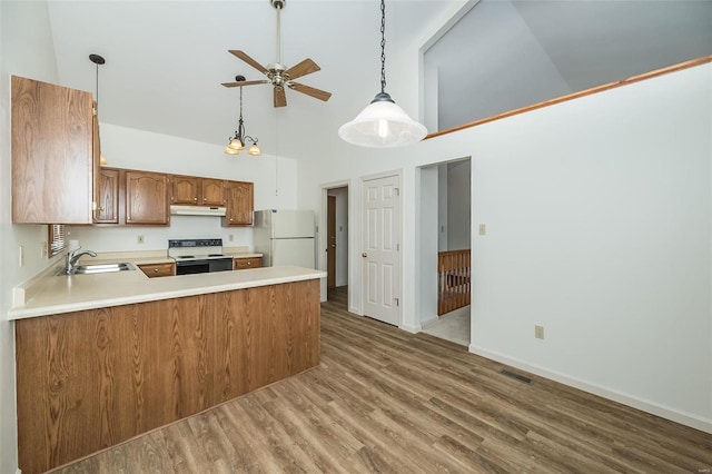 kitchen featuring kitchen peninsula, white refrigerator, high vaulted ceiling, and electric range oven