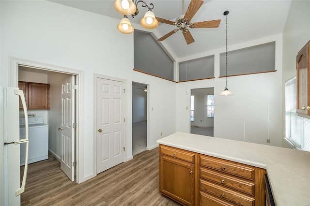 kitchen with white fridge, washer / clothes dryer, ceiling fan, and hanging light fixtures