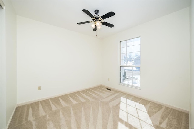 empty room featuring ceiling fan and carpet