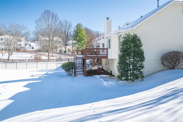 yard covered in snow with a deck