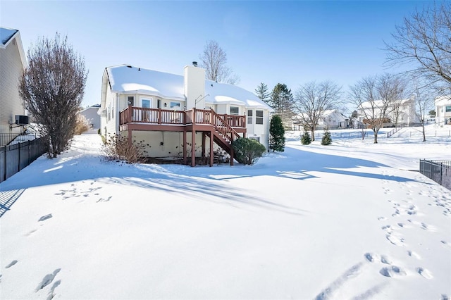 snow covered rear of property featuring a deck