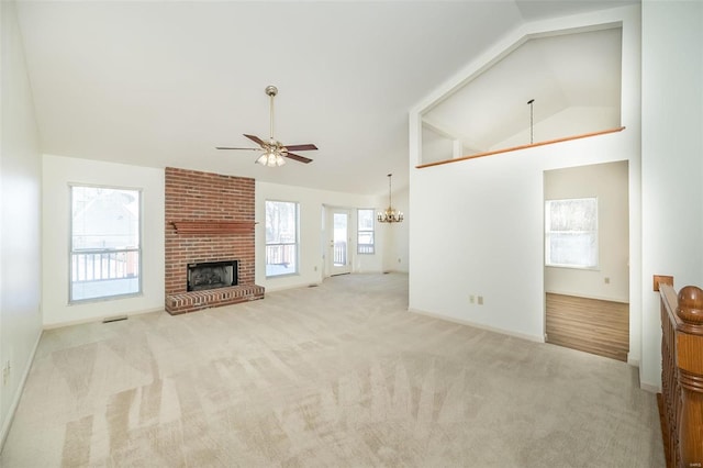 carpeted living room featuring ceiling fan with notable chandelier, vaulted ceiling, and a fireplace