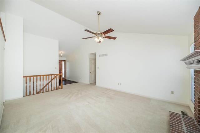 unfurnished living room featuring a fireplace, ceiling fan, vaulted ceiling, and light colored carpet