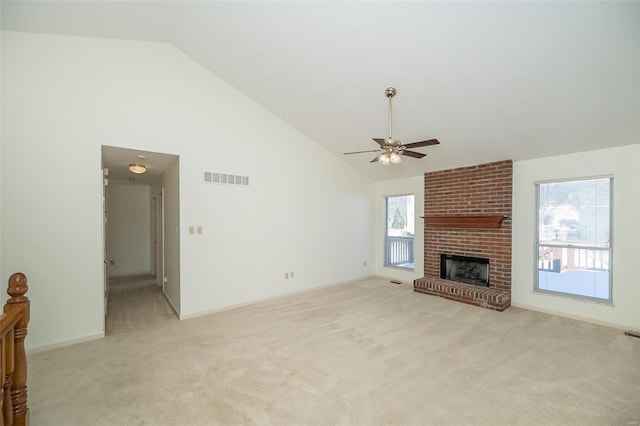 unfurnished living room with ceiling fan, light colored carpet, a brick fireplace, and high vaulted ceiling