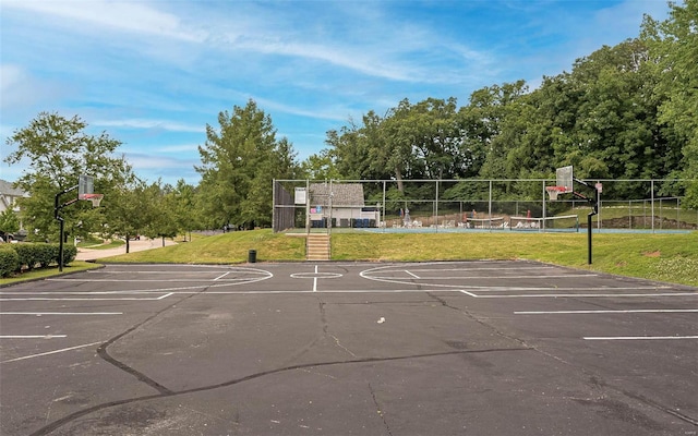 view of basketball court with volleyball court and a lawn