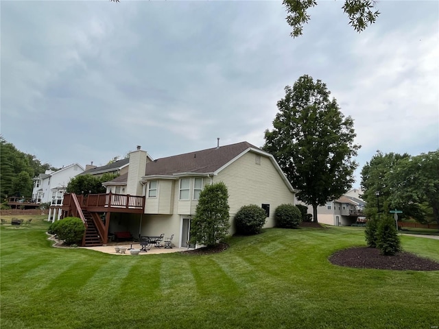 rear view of property featuring a patio, a deck, and a yard