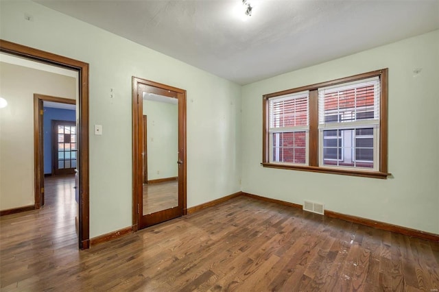 spare room with dark hardwood / wood-style floors and a wealth of natural light