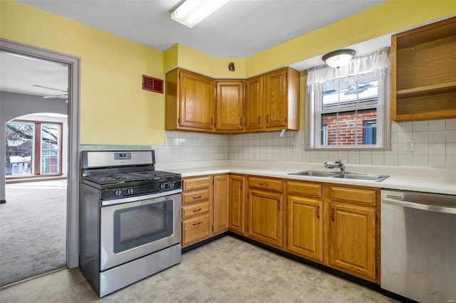 kitchen with light carpet, a wealth of natural light, sink, and stainless steel appliances