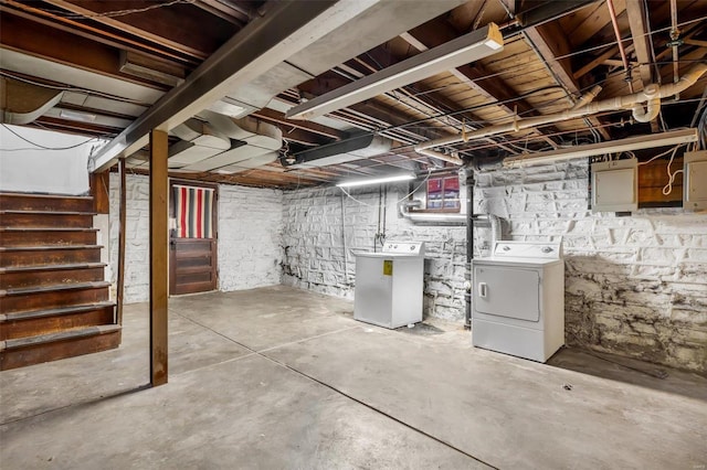 basement featuring washer and clothes dryer and electric panel