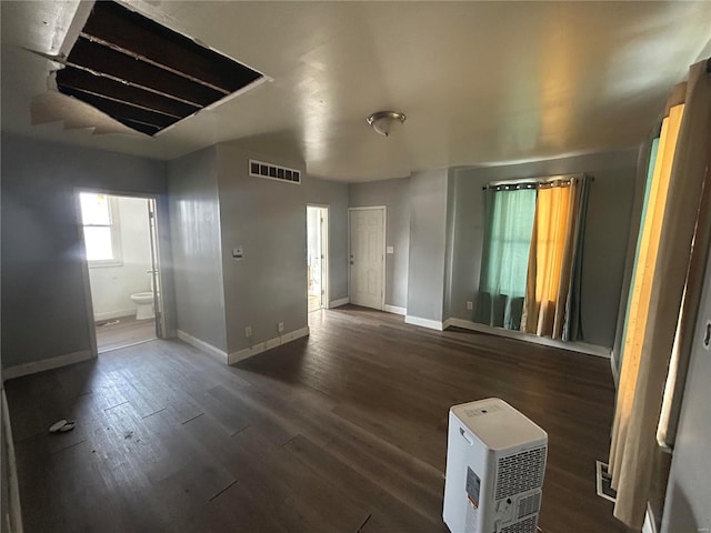 spare room featuring heating unit and dark hardwood / wood-style floors