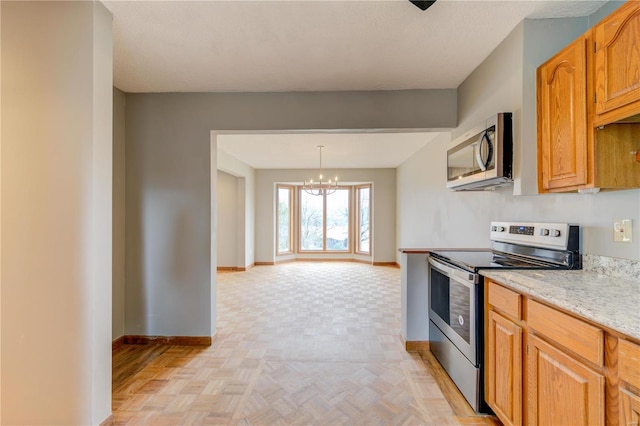 kitchen with a chandelier, pendant lighting, light parquet floors, and stainless steel appliances