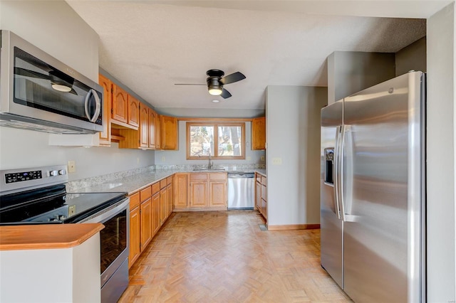 kitchen featuring ceiling fan, sink, light parquet floors, and appliances with stainless steel finishes