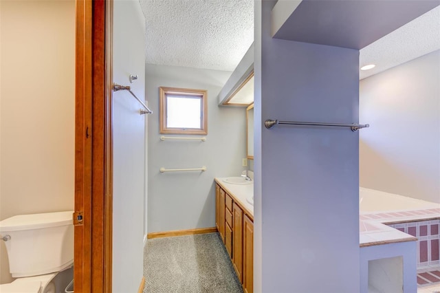 bathroom featuring vanity, a textured ceiling, and toilet