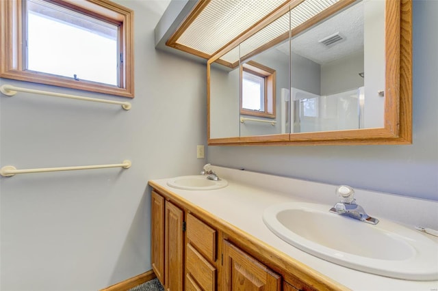 bathroom featuring a shower, vanity, and a textured ceiling