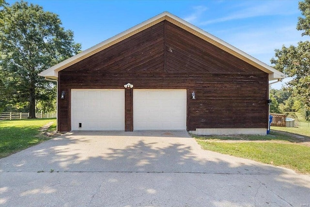 view of property exterior featuring a garage, fence, a lawn, and an outdoor structure