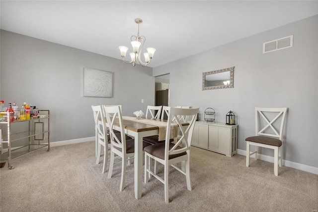 dining area featuring light colored carpet and a chandelier