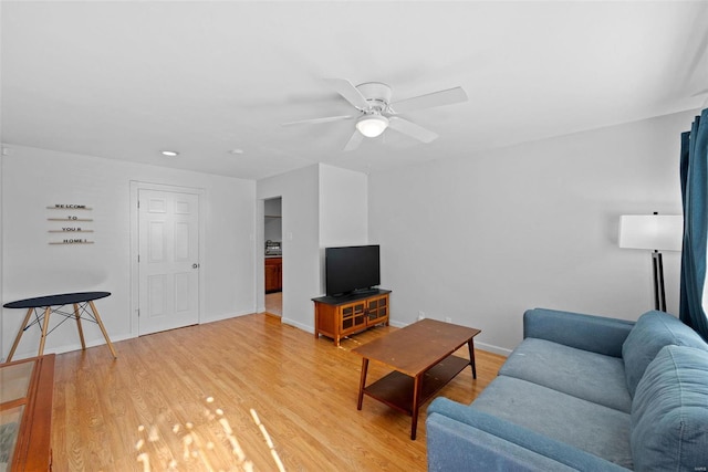 living room featuring ceiling fan and light hardwood / wood-style flooring