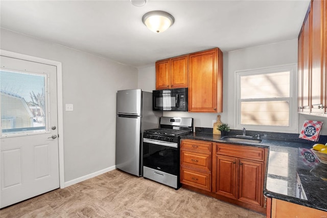 kitchen featuring sink, stainless steel appliances, and dark stone counters