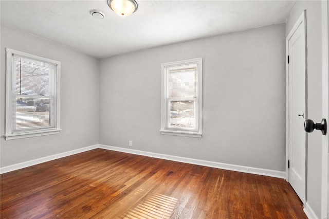 spare room with dark hardwood / wood-style flooring