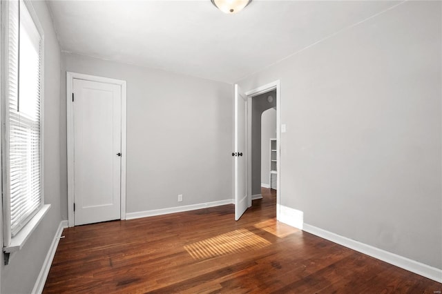 unfurnished room featuring dark wood-type flooring