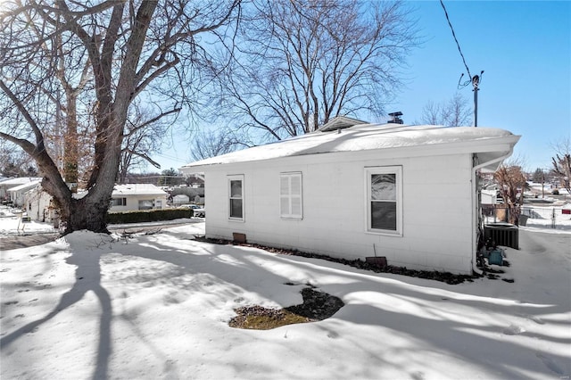 snow covered property with central AC