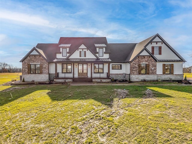 english style home with covered porch and a front yard