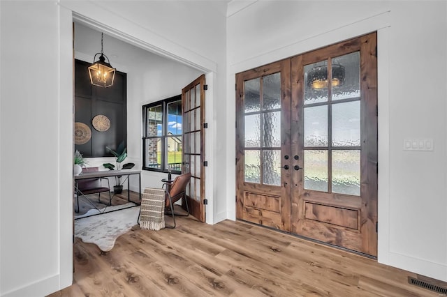 entryway with french doors, a healthy amount of sunlight, and hardwood / wood-style flooring