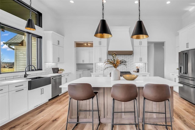 kitchen featuring custom exhaust hood, a center island, stainless steel appliances, and tasteful backsplash