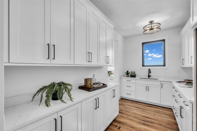 kitchen featuring light hardwood / wood-style floors, white cabinetry, and sink