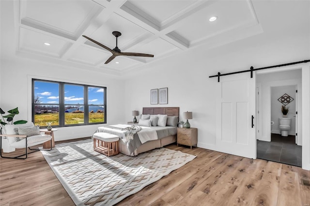 bedroom with ceiling fan, a barn door, connected bathroom, and coffered ceiling