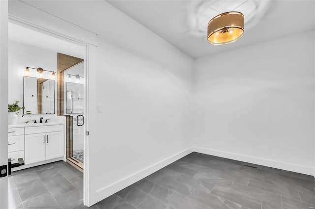 spare room with dark tile patterned flooring and sink