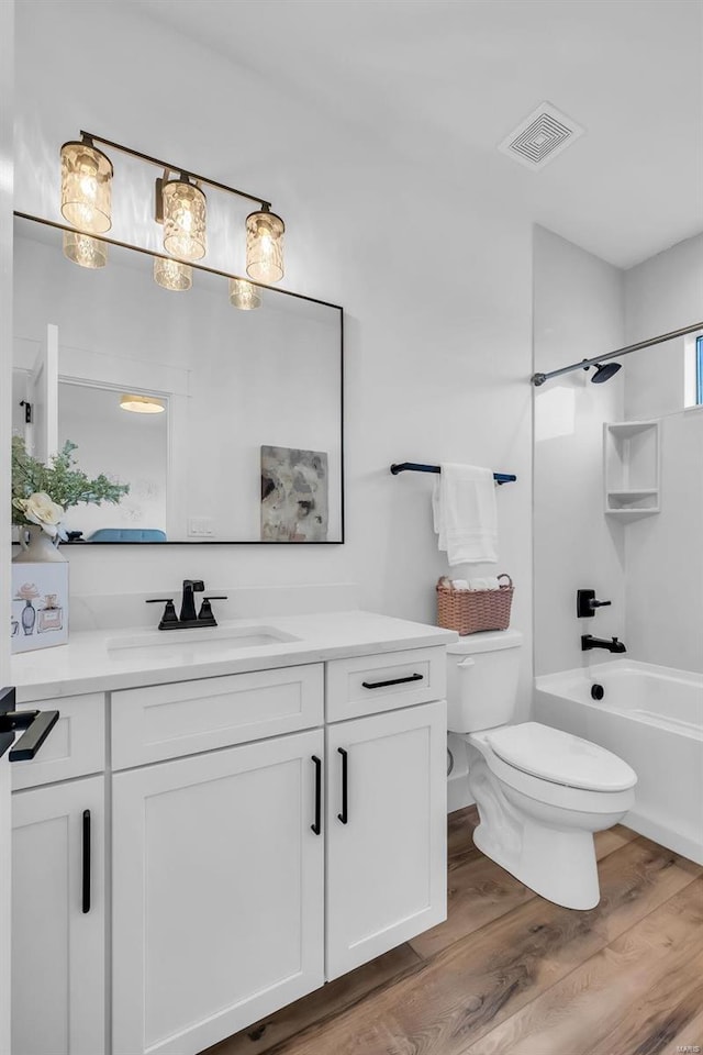 full bathroom with vanity, hardwood / wood-style flooring, toilet, and  shower combination