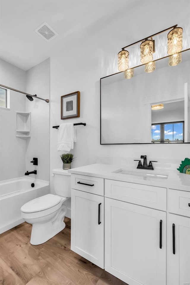 full bathroom featuring vanity, hardwood / wood-style flooring, toilet, and a healthy amount of sunlight