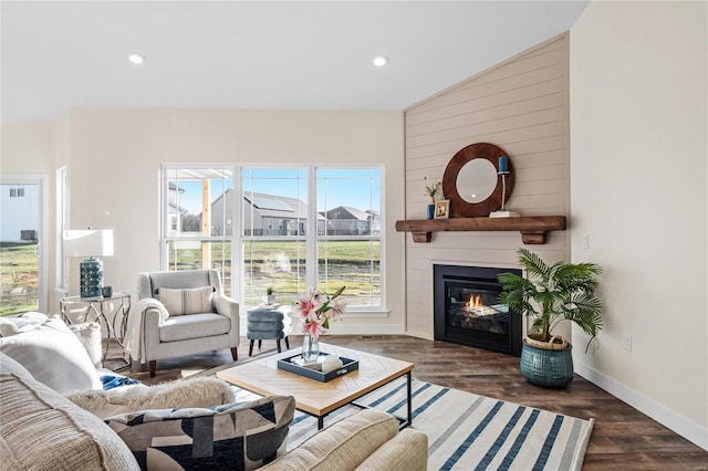 living room featuring dark wood-type flooring, a large fireplace, a healthy amount of sunlight, and lofted ceiling