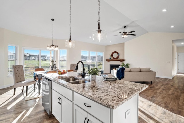 kitchen featuring sink, stainless steel dishwasher, lofted ceiling, a kitchen island with sink, and white cabinets