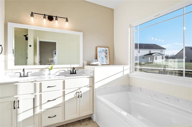 bathroom with a bath, vanity, tile patterned floors, and a wealth of natural light